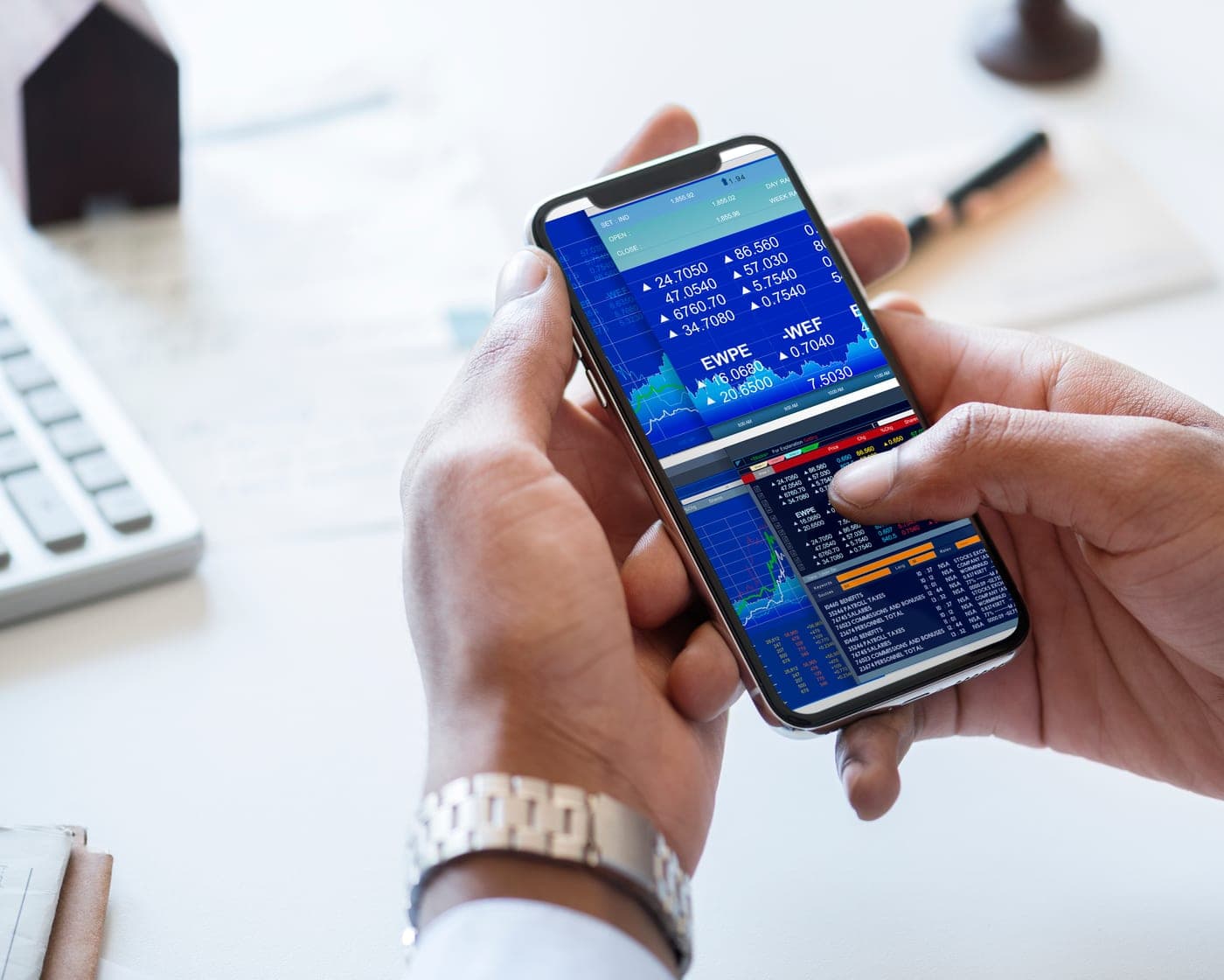 Hands holding a phone showing live market prices